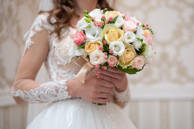 Manos de la novia con un ramo de rosas de cerca