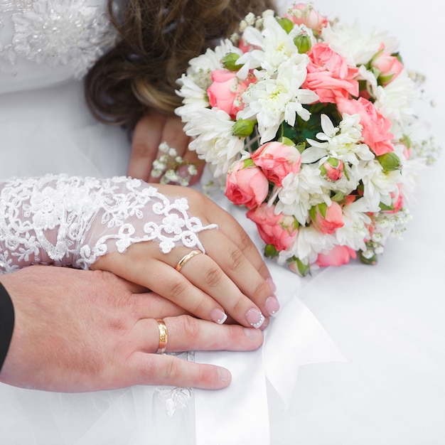 Manos del novio y la novia con anillos de boda