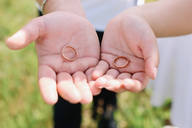 Foto manos de novios con anillos de oro. día de la boda, novios. detalles de la boda