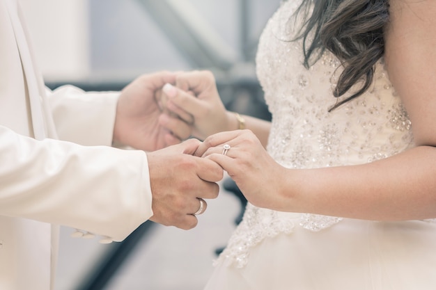 Manos de novios con anillos.