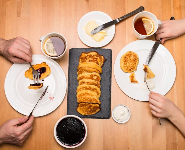 Manos de padre e hijo en la mesa del desayuno Hora del té Té familiar con panqueques caseros