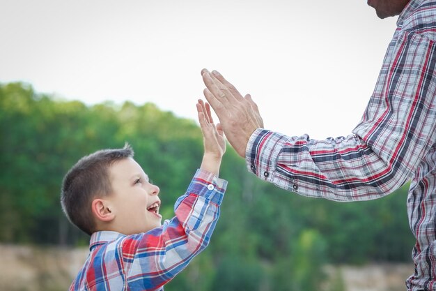 Foto a manos de padre e hijo en la naturaleza en el viaje al parque