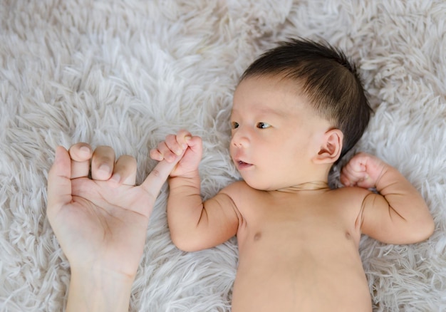 manos de los padres sosteniendo los dedos del bebé recién nacido