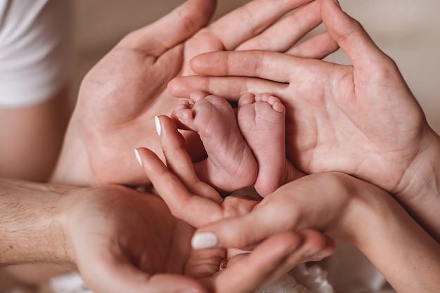 manos de los padres sostienen los pies del bebé