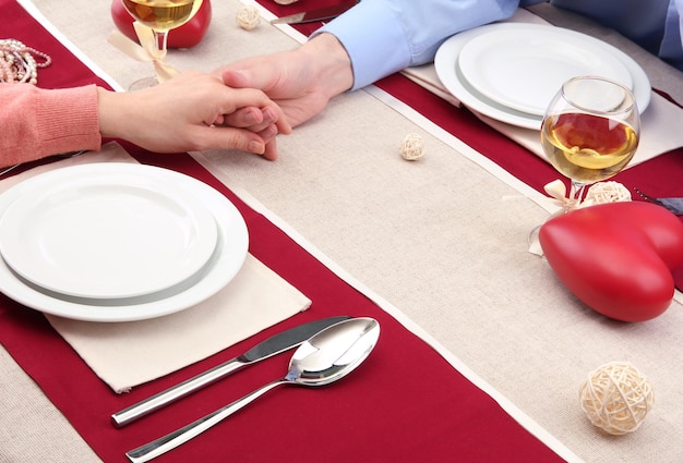 Manos de pareja romántica sobre una mesa de restaurante