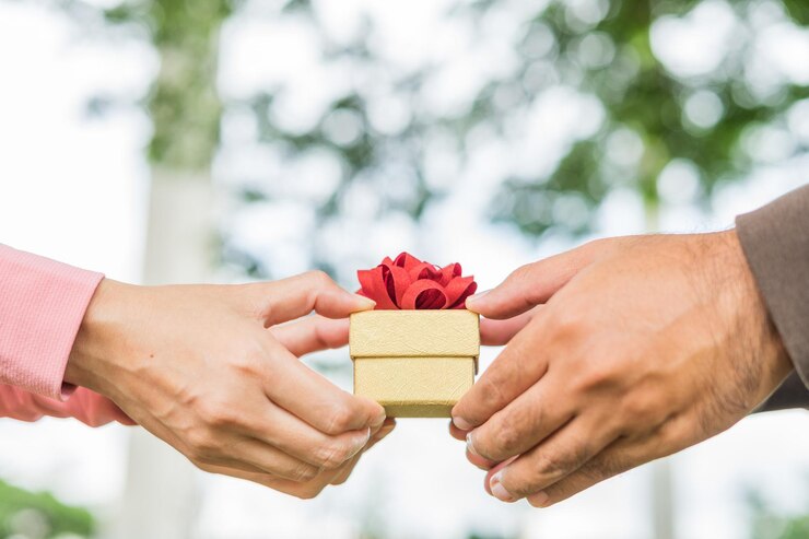 Manos pareja sosteniendo regalo empaquetado juntos Manos mujer y hombre sosteniendo un regalo envuelto con cinta en el parque para cumpleaños Navidad Año nuevo Valentines Celebrar graduados