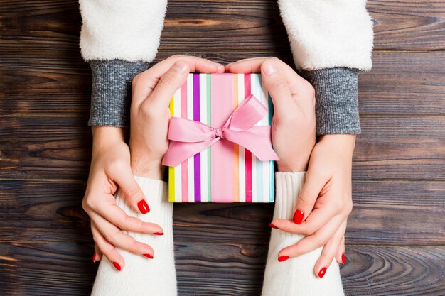 Manos de la pareja sosteniendo un regalo de Navidad