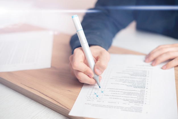 Foto las manos de la persona de cerca escribiendo respuestas en la prueba social en una hoja de papel