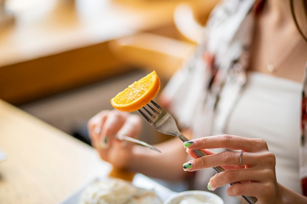 manos de una persona con un pastel y naranja