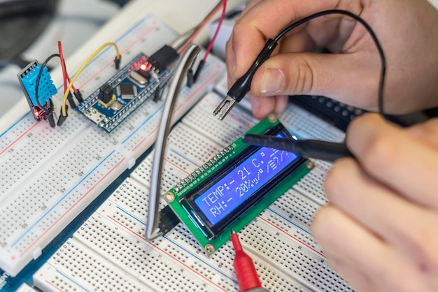 Las manos de las personas conectan o instalan un chip o sensor de silicio eléctrico b