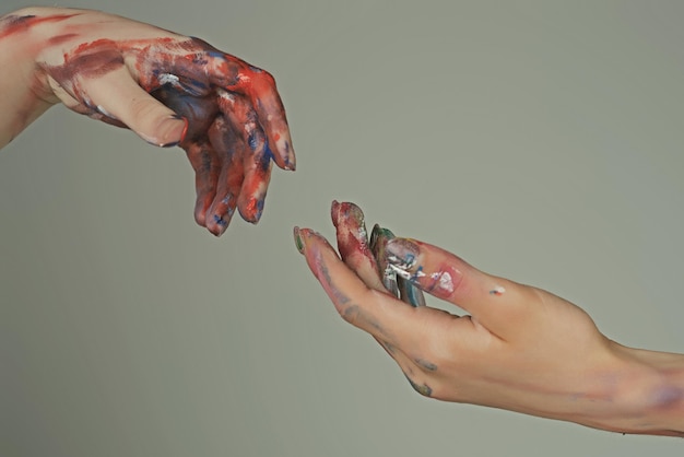 Las manos pintadas alcanzan la mano concepto esperanzador dos manos tratando de tocar a Adán signo de relación humana
