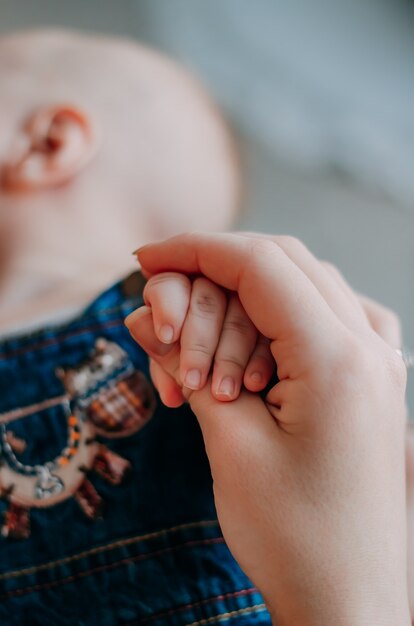 Manos de primer plano de mamá, madre y bebé