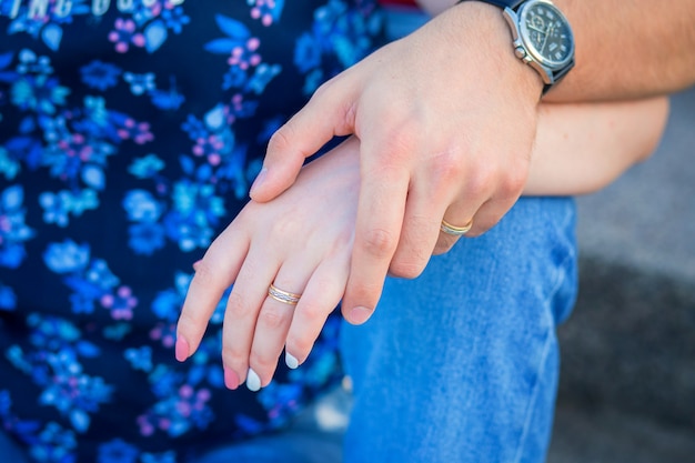 Manos de un primer plano de pareja abrazando. La mano del hombre lucha contra la mano de una mujer