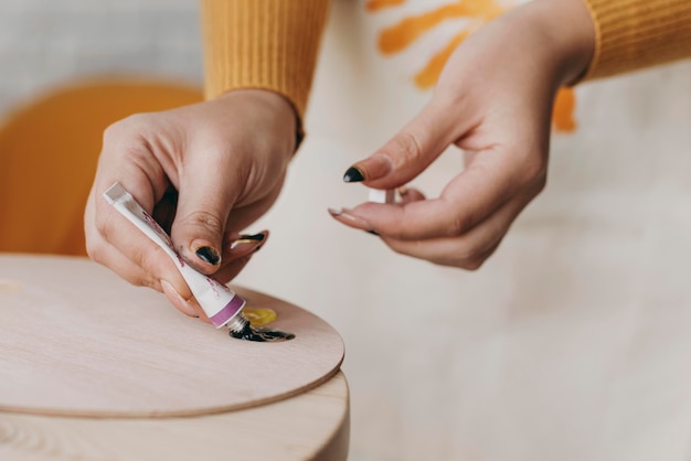 Foto manos de primer plano con tubo de pintura