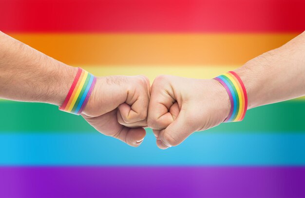 Foto manos con pulseras de orgullo gay hacen golpe de puño