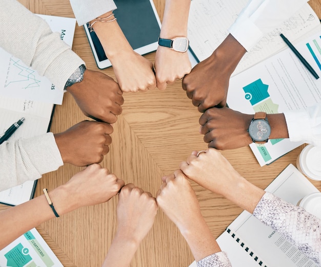 Manos de puño de diversidad y trabajo en equipo con documentos en la mesa para reuniones de negocios de marketing colaboración creativa y objetivos que apoyan la motivación Mano del círculo del equipo y estrategia de planificación o logística