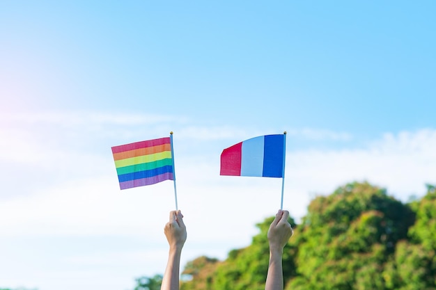 Manos que muestran la bandera LGBTQ Rainbow y Francia en el fondo de la naturaleza Apoyar a la comunidad lesbiana gay bisexual transgénero y queer y el concepto del mes del orgullo