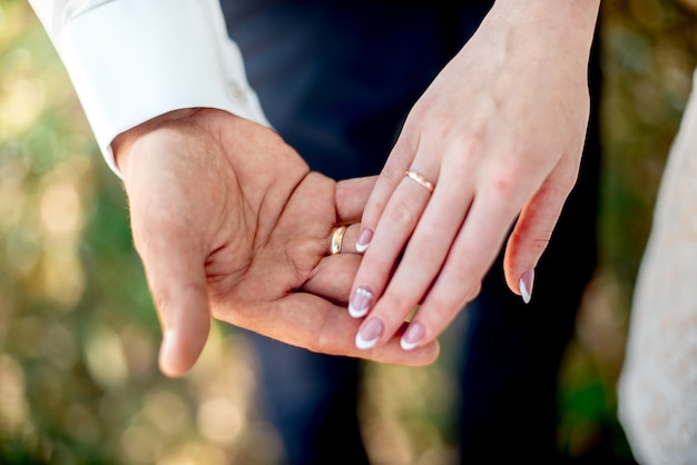 Manos de recién casados con anillos de boda