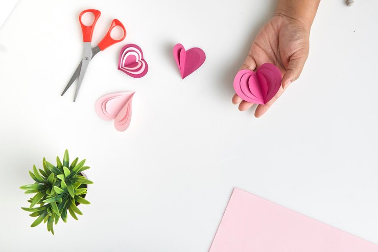 Foto manos recortadas haciendo papel en forma de corazón sobre fondo blanco