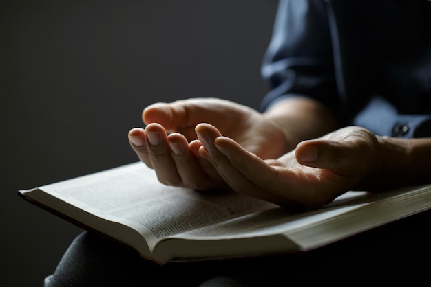 Foto manos rezando el hombre reza con las manos juntas sobre una santa biblia en el concepto cristiano de la fe