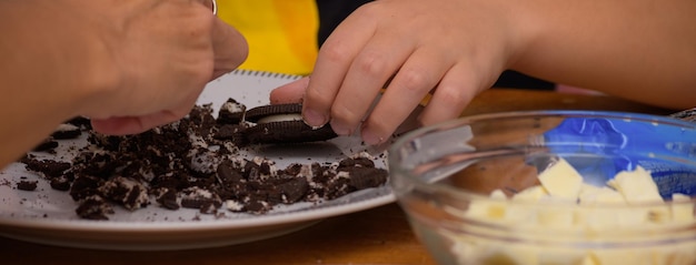 Manos rompiendo galletas para hacer huevos de Pascua