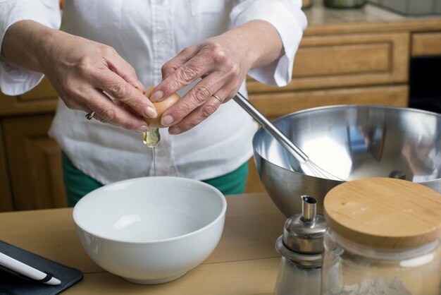 Foto manos rompiendo huevos en un tazón; de cerca