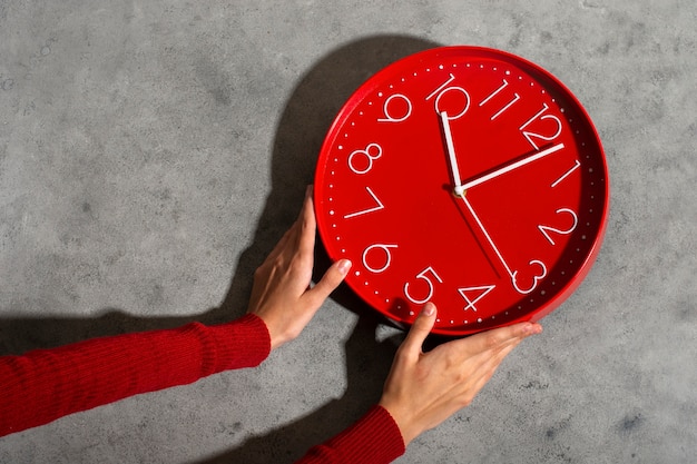 Foto manos sosteniendo bodegón de reloj de pared