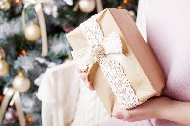 Manos sosteniendo caja de regalo de Navidad