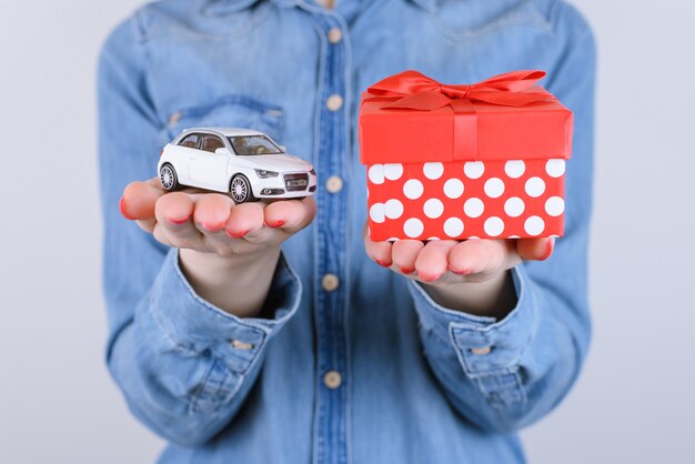 Manos sosteniendo coche de juguete y caja actual