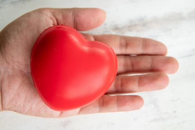 Manos sosteniendo el concepto de corazón, amor y cuidado de goma roja