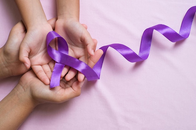 Foto manos sosteniendo el concepto de día mundial del cáncer de cintas moradas, enfermedad de alzheimer, cáncer de páncreas, conciencia de la epilepsia, conciencia de la violencia doméstica, conciencia de la fibromialgia