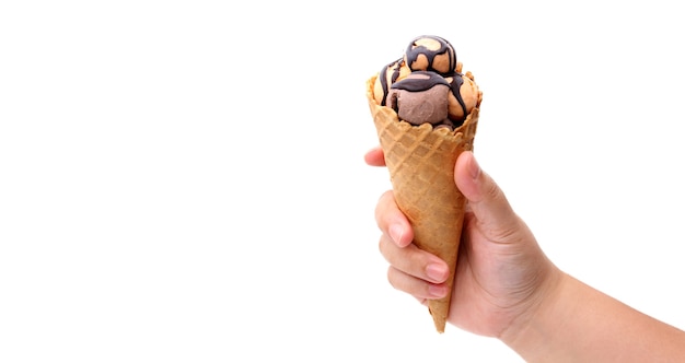 Foto manos sosteniendo el cono de gofre fresco de helado sobre fondo blanco.