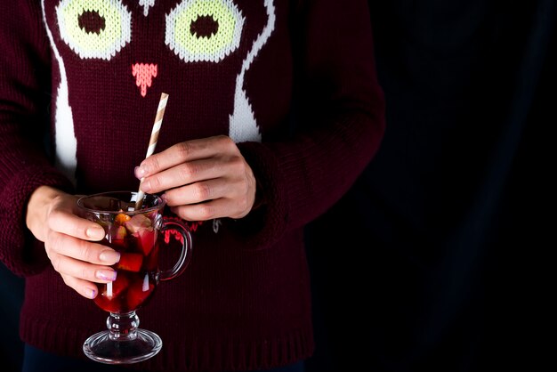 Manos sosteniendo una copa de vino caliente