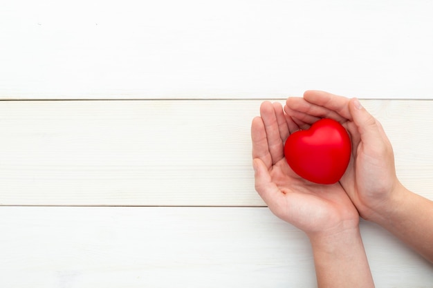 Foto manos sosteniendo corazón rojo, cuidado de la salud, amor, san valentín, indefenso, donación, atención plena, bienestar