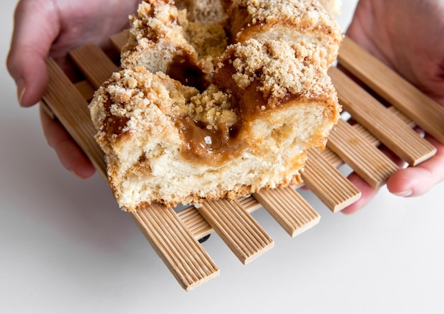 Manos sosteniendo cuca brasileña tradicional rellena con dulce de leche