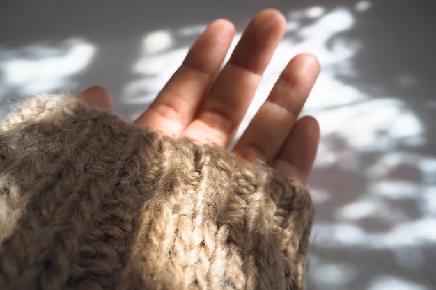 Manos sosteniendo la luz del sol en invierno