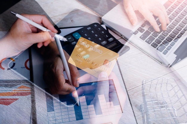 Foto manos sosteniendo una tarjeta de crédito y usando una computadora portátil compras en línea