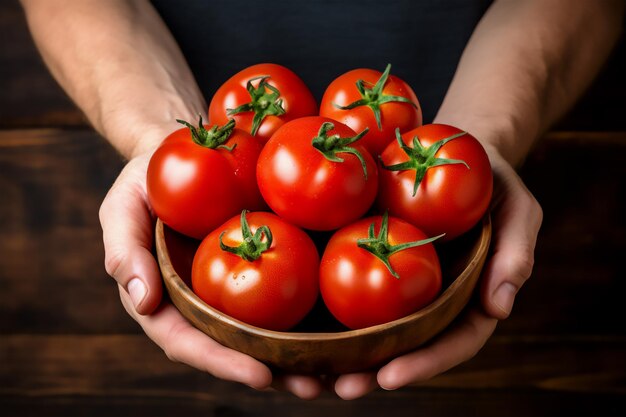 Manos sosteniendo tomates en el cuenco