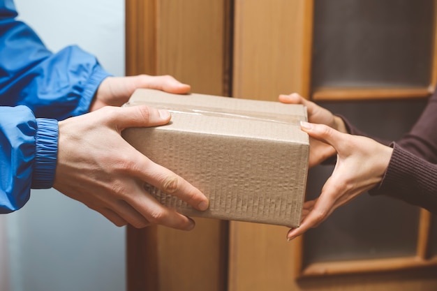 Las manos sostienen una caja de entrega.