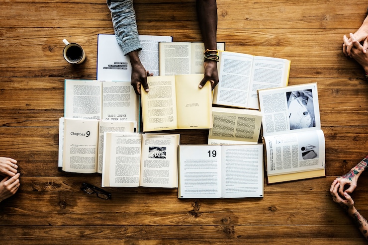 Foto manos sostienen libros abiertos novela