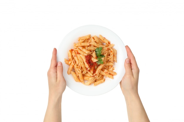 Las manos sostienen el plato con sabrosa pasta, aislado en la pared blanca