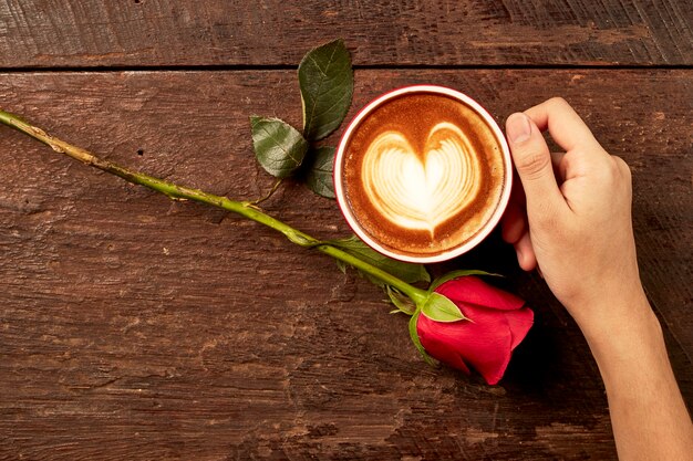 manos una taza de café en forma de corazón