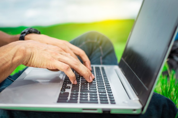 Manos en el teclado de la computadora portátil, cerca de las manos en el teclado