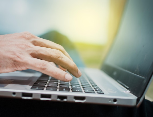 Manos en el teclado de la computadora portátil, cerca de las manos en el teclado