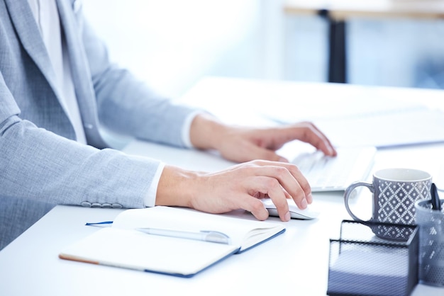 Manos de teclado y primer plano de una mujer escribiendo en la computadora para investigar en la oficina Profesional de tecnología y empleada que trabaja en un proyecto corporativo con computadora de escritorio y portátil en el lugar de trabajo