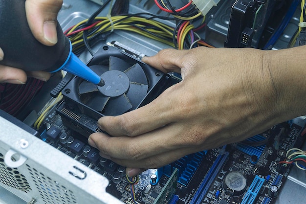 Foto las manos de un técnico de computadoras limpiando el ventilador de la cpu de la computadora