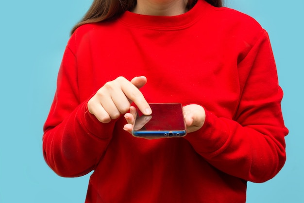 Manos con teléfono móvil. mujer escribiendo mensajes de texto en el teléfono inteligente