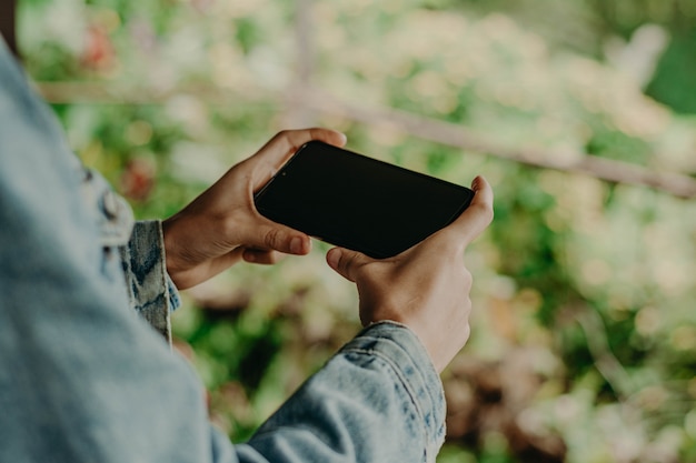 Manos con un teléfono negro. teléfono inteligente