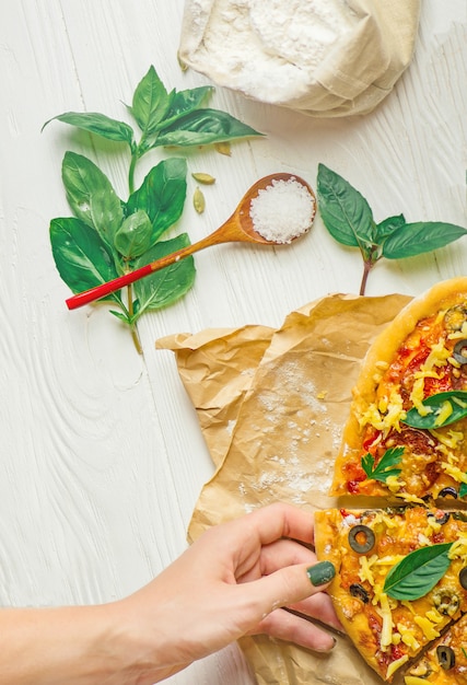 Manos tomando rodajas de pizza. Mano que sostiene la rebanada de pizza.