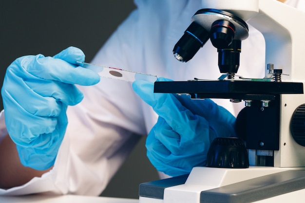 Manos de un trabajador de laboratorio haciendo análisis de sangre